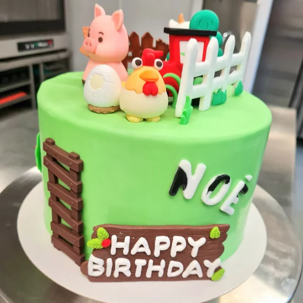 Gâteau haut vert avec des personnages en pâte à sucre