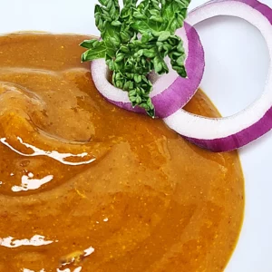 Sauce curry avec deux fines lamelles d'oignon rouge et une branche de persil