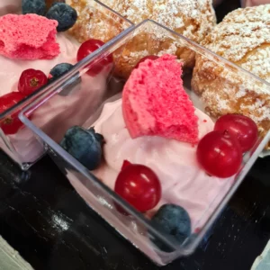 Verrine avec de la mousse aux fruits rouges et des fruits rouges en décoration
